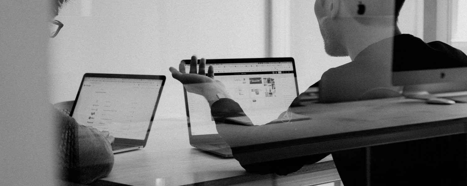 Homme devant son ordinateur au travail, en noir et blanc
